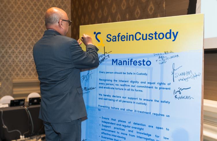 A conference participant signs the #SafeInCustody Manifesto